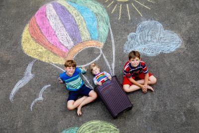 drie kinderen voor een krijttekening van een luchtballon